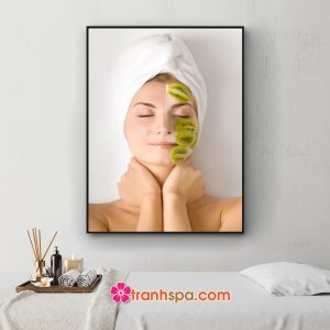 Bức tranh spa khổ dọc đẹp hình ảnh cô gái với khuôn mặt xinh và nước da đẹp đắp trái kiwi