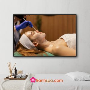 Mẫu tranh trang trí spa đep hình ảnh nhân viên chăm sóc da mặt cho khách hàng