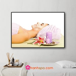 Mẫu tranh treo spa đẹp hình ảnh nữ khách hàng đang nằm đắp mặt nạ dưỡng da bên cạnh là đĩa hoa ly nến thơm và đá