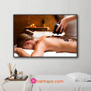 Mẫu tranh treo spa đẹp hình ảnh nhân viên thẩm mỹ viện đang đổ bùn chăm sóc da làm đẹp trên lưng của nữ khách hàng