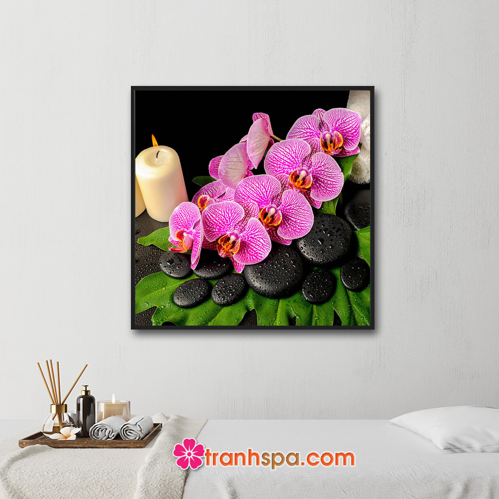 Mẫu tranh trang trí spa đẹp khổ vuông hình ảnh cành hoa lan tím, đá cuội đen đặt trên tàu lá xanh, nến thơm và khăn tắm