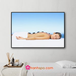 Mẫu tranh trang trí spa đẹp hình ảnh nữ khách hàng nằm thư giãn chườm đá nóng trên lưng phía sau là biển xanh và mây trời trong lành