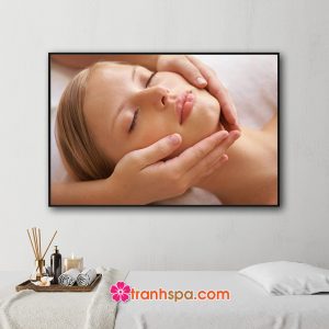 Mẫu tranh treo spa đẹp hình ảnh nhân viên đang massage mặt cho nữ khách hàng nằm thư giãn