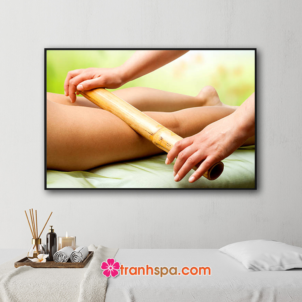Mẫu tranh treo spa đẹp hình ảnh nhân viên đang dùng thanh tre để massage chân cho khách hàng