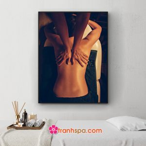 Mẫu tranh trang trí spa đẹp hình ảnh nhân viên massage lưng cho khách hàng trong không gian ánh sáng ấm áp