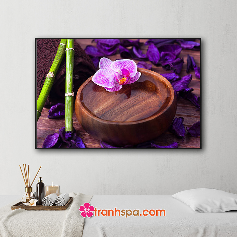Mẫu tranh trang trí spa đẹp hình ảnh hoa lan và những cánh hoa màu tím, bát gỗ đựng nước tinh khiết, những cành lộc xanh...trên nền gỗ màu nâu và ánh sáng trầm ấm