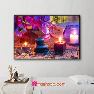 Mẫu tranh trang trí spa đẹp hình ảnh hoa lan tím, khăn tắm, đá cuội và những ngọn nến thơm tỏa ánh sáng màu tím lung linh