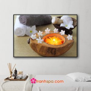 Mẫu tranh trang trí spa đẹp hình ảnh những cuộn khăn tắm, túi chườm, vỏ dừa chứa nến thơm hình hoa sứ đẹp tỏa ánh sáng vàng