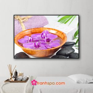 Mẫu tranh trang trí spa đẹp hình ảnh bát gỗ đựng nước và những bông hoa lan tím, khăn tắm cuộn tròn, đá cuội đen bóng và những chiếc lá dừa xanh