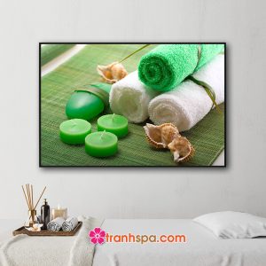 Mẫu tranh trang trí spa đẹp hình ảnh khăn tắm xanh và trắng cuộn tròn, nền thơm xanh, xà bông, vỏ ốc đặt trên tấm thảm xanh