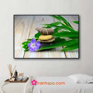 Mẫu tranh trang trí spa đẹp hình ảnh lá trúc xanh, hoa tím, những viên đá vân đẹp đặt trên nền gỗ