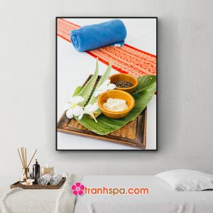 Mẫu tranh spa khổ dọc đẹp hình ảnh cuộn khăn tắm xanh và dải vải thổ cẩm, khay chứa tàu lá, hoa lan, nha đam và bát muối tắm