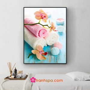 Mẫu tranh spa khổ dọc đẹp hình ảnh cành hoa lan, các cuộn khăn tắm, nến thơm và soap đặt trên nền gỗ xanh xước đẹp