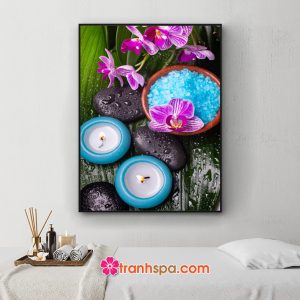 Mẫu tranh trang trí spa đẹp khổ dọc hình ảnh cành hoa lan tím, muối tắm xanh, nến thơm, đá cuội trên nền tàu lá xanh vương nước tinh khiết